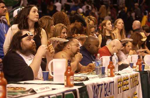 Damaging Doug (left), Chili Dog (middle) and Eric "Badlands" Booker compete in Wing Bowl 12 in 2004 at the Wachovia Center.
