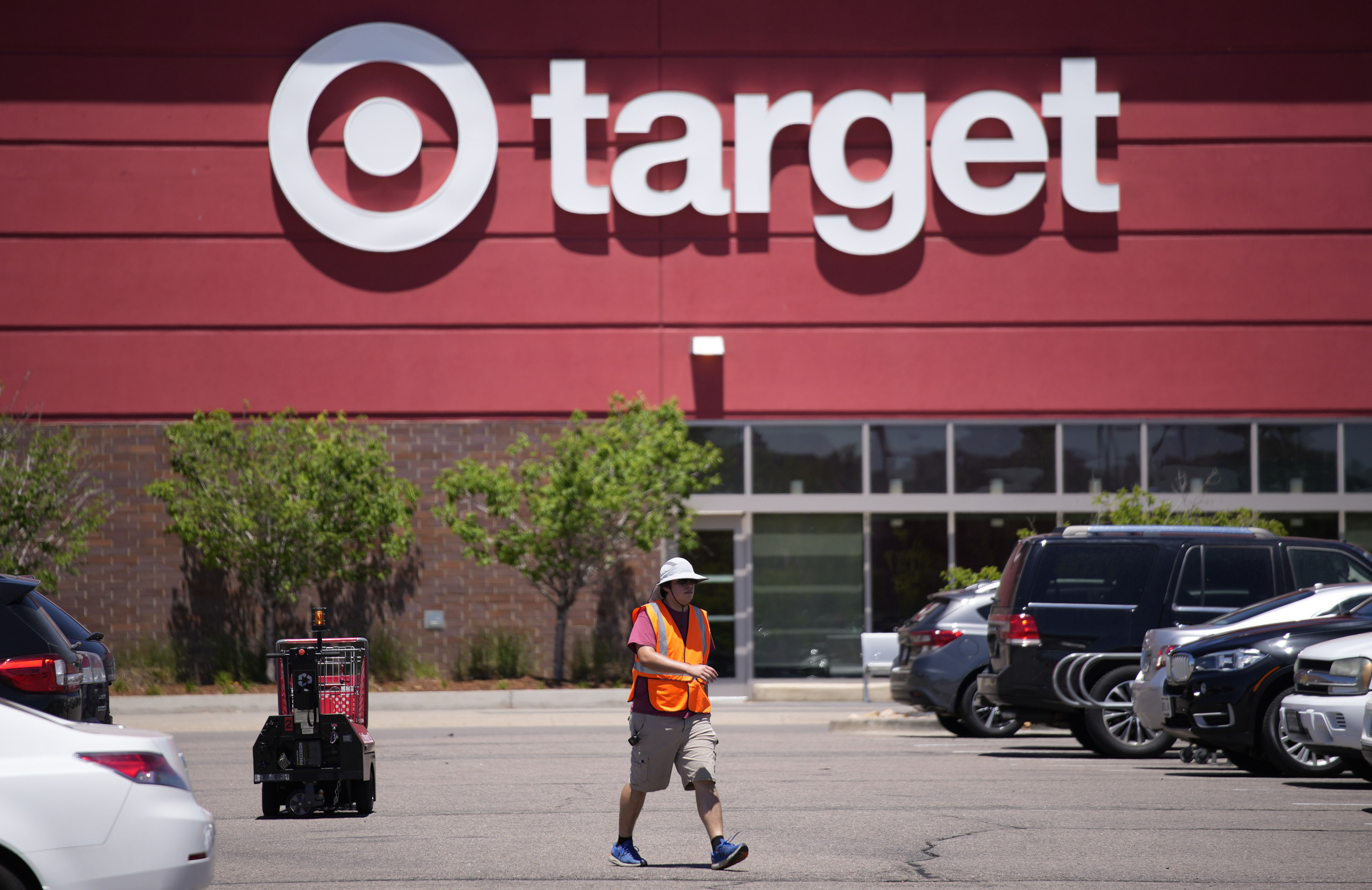 A worker collects shopping carts in the parking lot of a Target store in Highlands Ranch, Colo., in 2021.