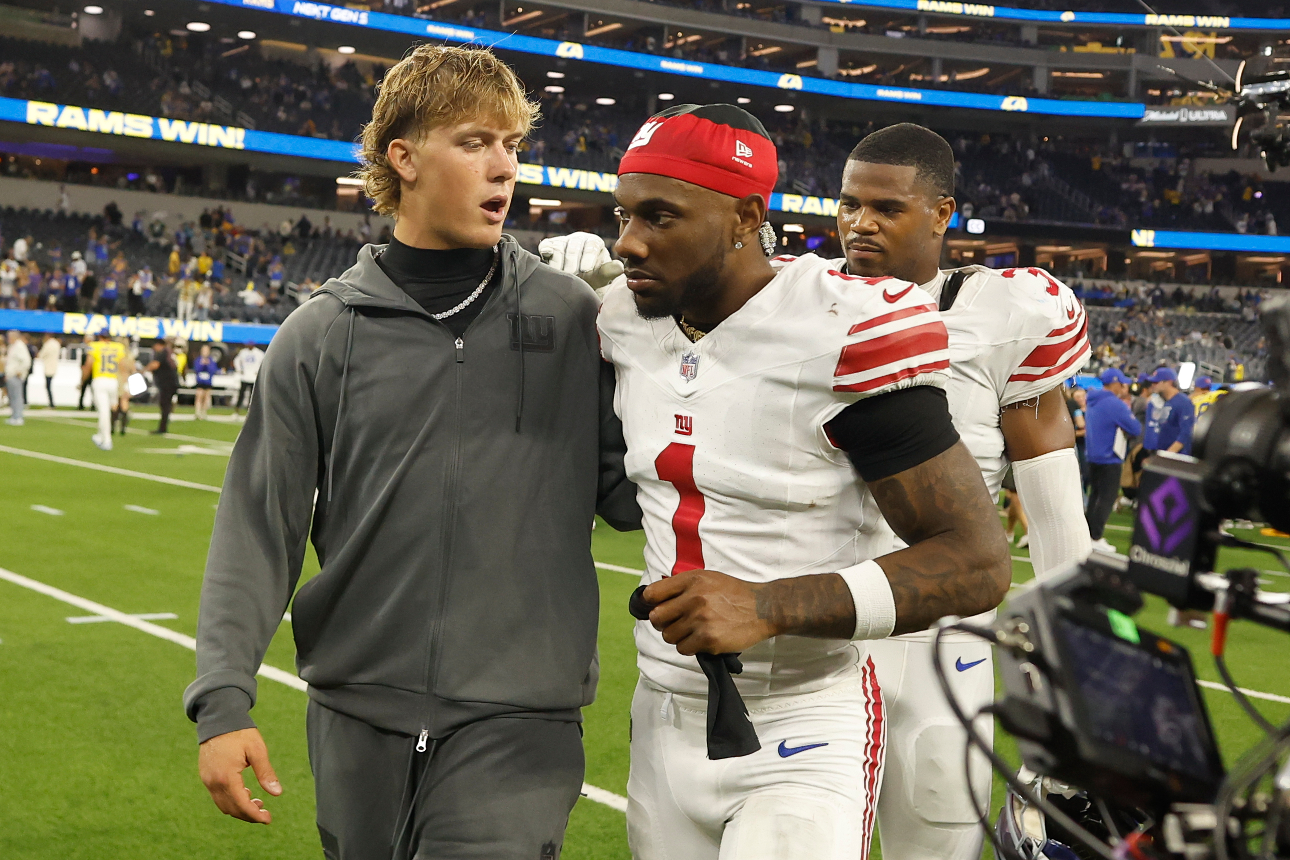 Injured Giants quarterback Jaxson Dart (left) walks off the field with wide receiver Malik Nabers after their loss to the Rams on Monday night.