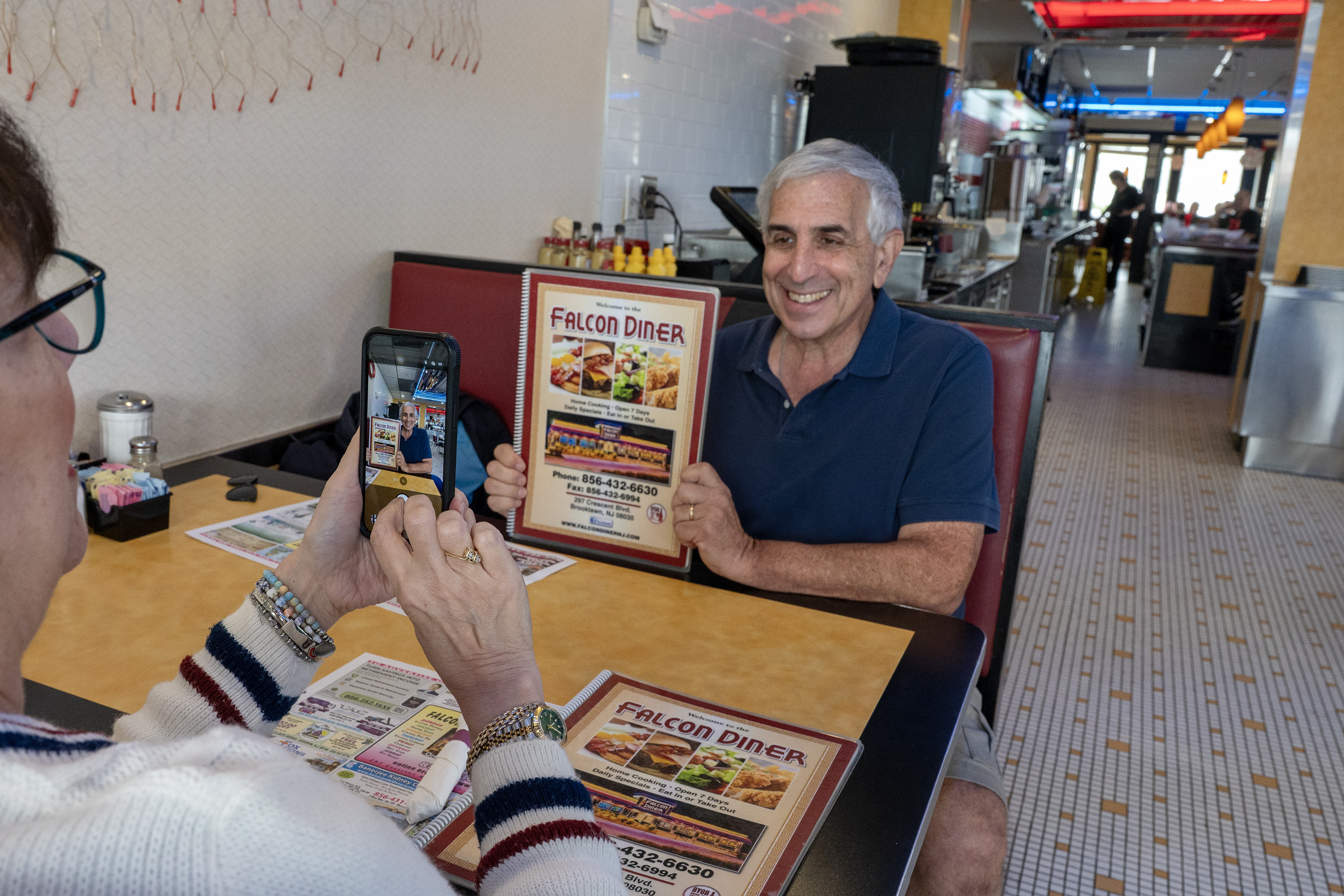 Karri Ricklin photographs Jon Ricklin holding a menu at the Falcon Diner on the Brooklawn Circle on Sept. 30.