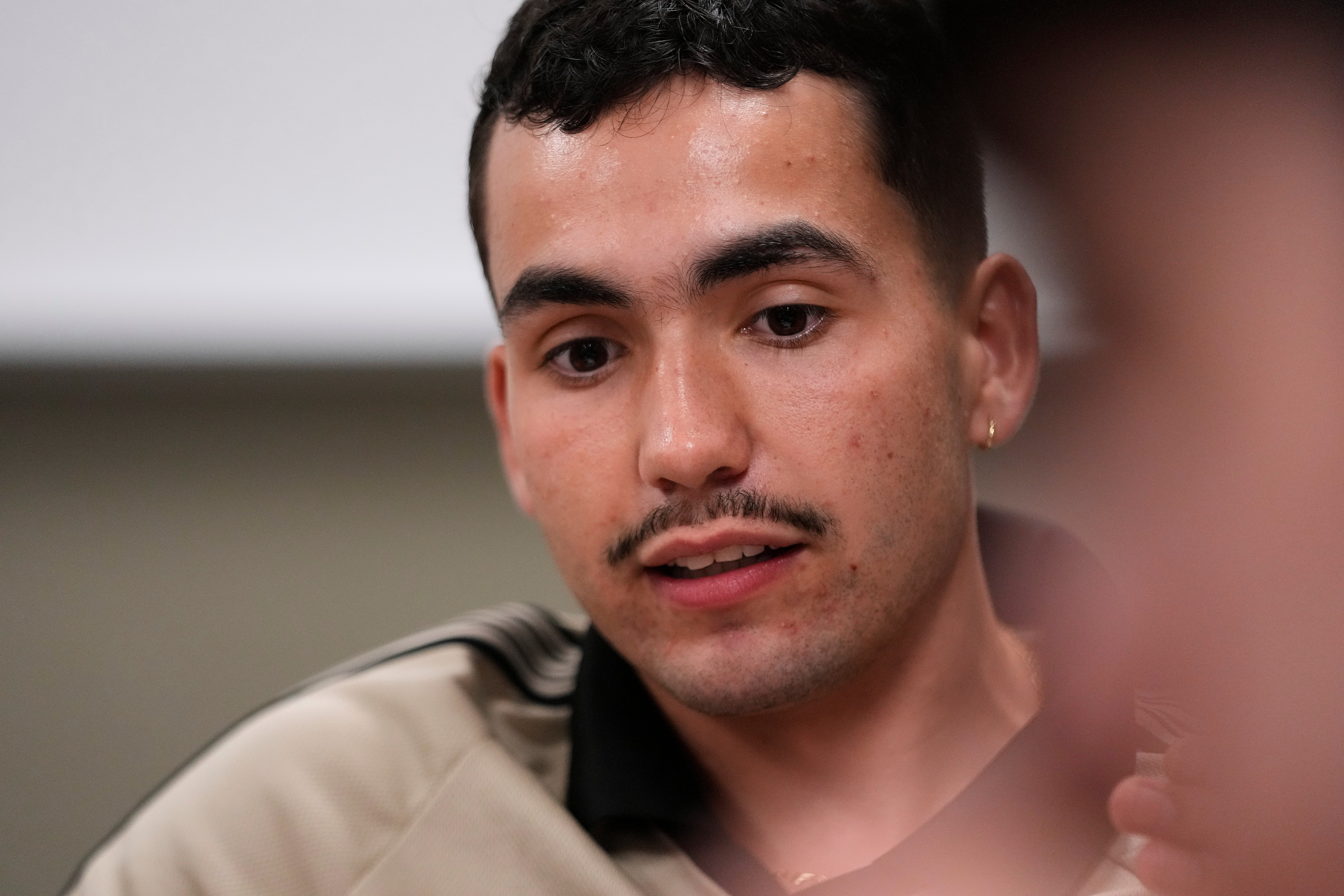 Michigan State University senior Frankie Llerandi listens to a discussion at a campaign event for William Lawrence, the Democratic candidate for U.S. House of Representatives in Michigan's 7th District, on Sept. 15, 2026, in East Lansing, Mich.